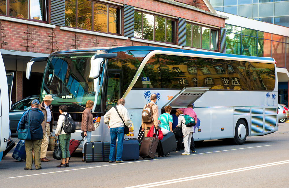 Passeggeri che caricano i bagagli su un autobus